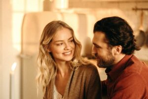 Pareja sonriendo y mirándose con complicidad, reflejando confianza y conexión emocional a través de una sonrisa saludable